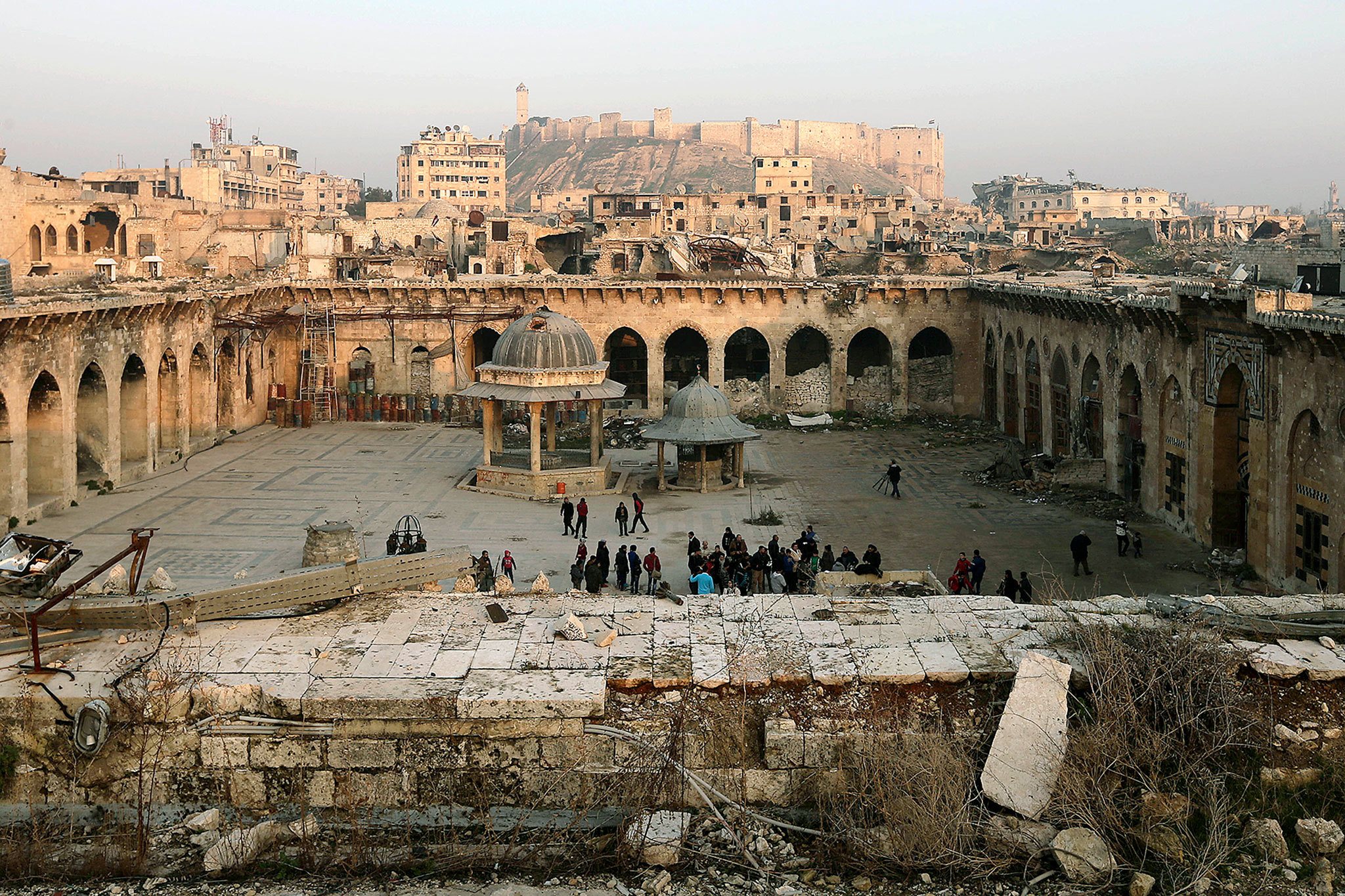 The Aleppo citadel, background, as people visit the heavily damaged inside of the Grand Umayyad mosque in the old city of Aleppo, Syria, on Thursday. (AP Photo/Hassan Ammar)