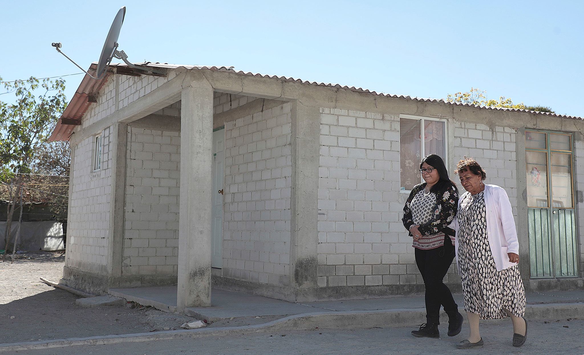 Tamara Alcala Dominguez walks with her grandmother, Petra Bello Suarez, in their hometown of Molcaxac, Puebla, Mexico, during Alcala&rsquo;s first return home since she left Mexico for the U.S. as a toddler. (AP Photo/Pablo Spencer)