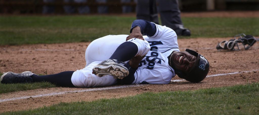 The AquaSox’s Kyle Lewis grabs his right knee after colliding with Tri-City catcher in the AquaSox’s lost to the Tri-City Dust Devils 8-6 at Everett Memorial Stadium on July 19, 2016, in Everett. Lewis, the Mariner’s No. 1 draft pick, did not return to play during the game. ( Andy Bronson / The Herald )
