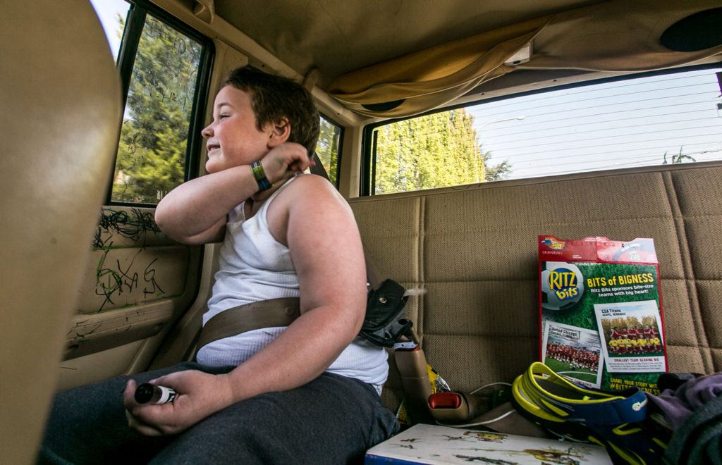 Jessie Pyles rides is his customary seat on the way home from the dentist’s office. The family tries not let Jessie ride in any other vehicles due the damage he causes and his ever-present black marker. (Kevin Clark / The Herald)

