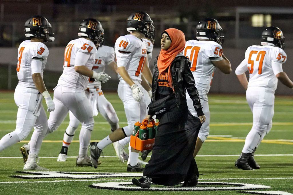 Xeyneb Al’Azadi, sophomore at Monroe High School, walks off the field after providing water to the players Friday night at Veterans Memorial Stadium in Snohomish, Washington on September 30, 2016. (Kevin Clark/The Herald)