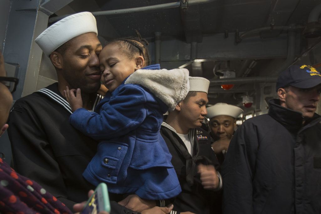 As his fellow crew heads to the mess hall to meet their families, Seaman Sean Tender and daughter Sydney, 2, hold each other after the USS Kidd docks at Everett Naval Station on Monday, Nov. 21, 2016 in Everett. (Andy Bronson / The Herald)