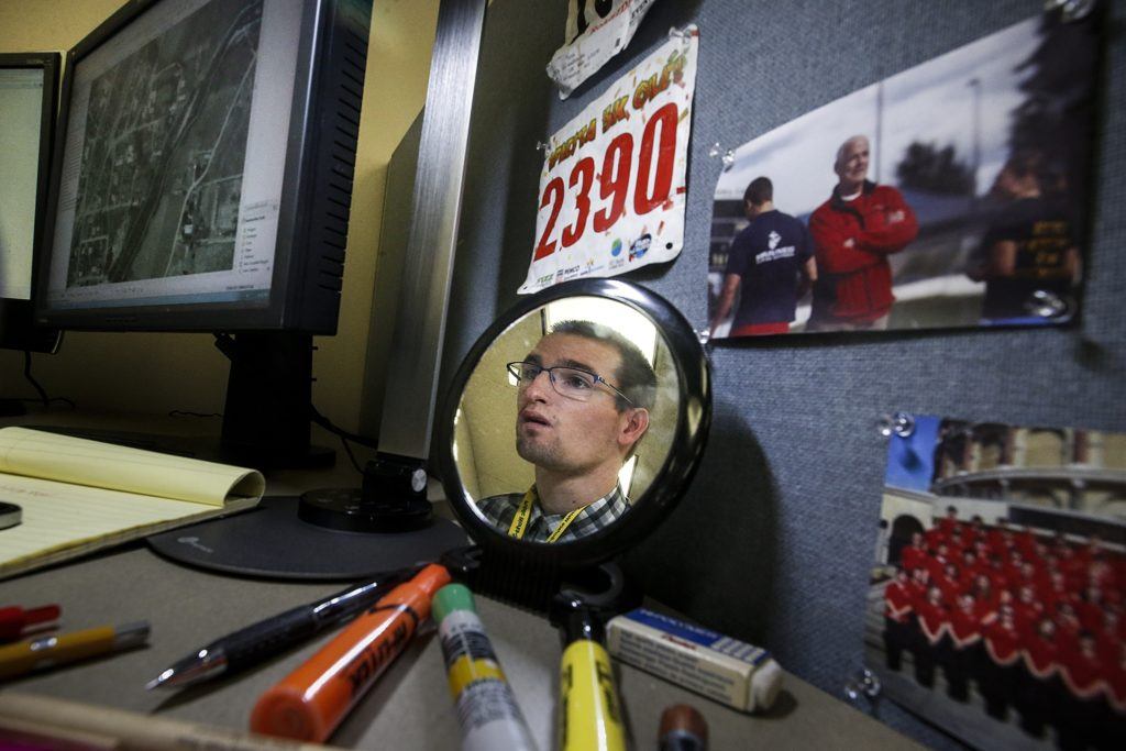 Joe Godfrey is reflected in a mirror on his desk while working on a computer-mapping project of a section of the Pilchuck River near Snohomish while at work in Everett on Nov. 3, 2016. (Ian Terry / The Herald)
