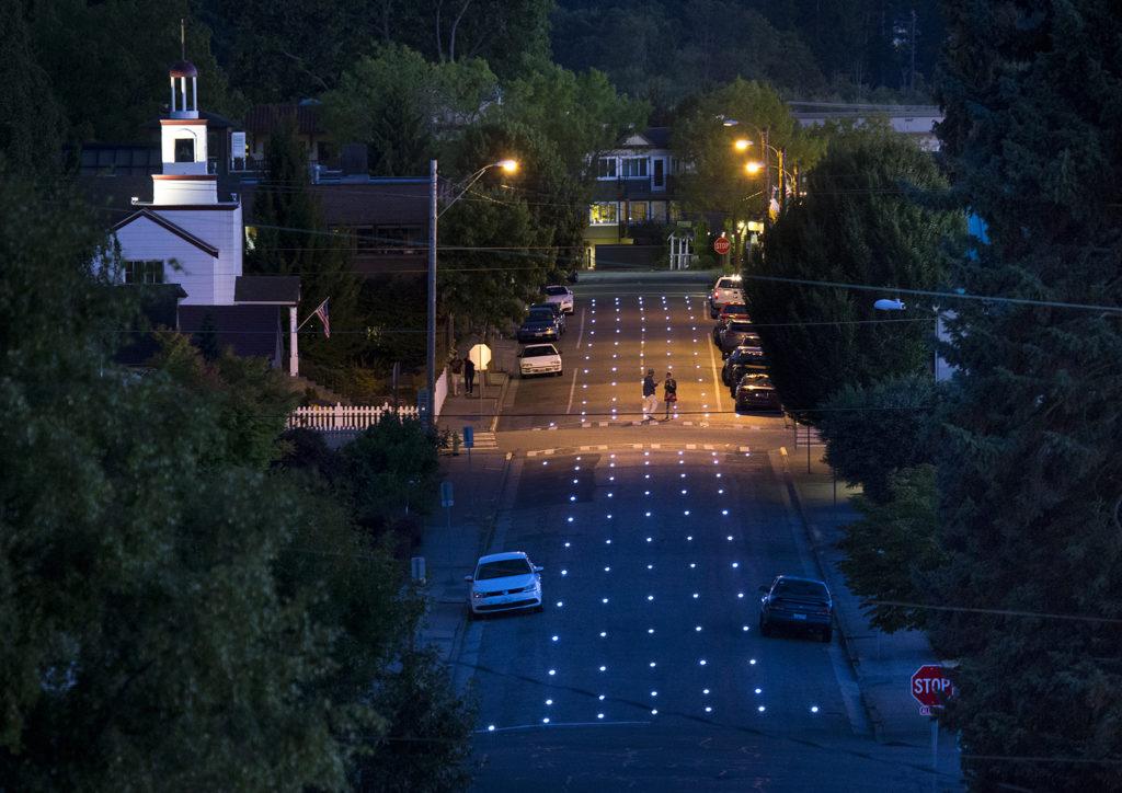 Artist Iole Alessandrini’s public art project, “Luminous Forest”, is seen on 4th Avenue in downtown Edmonds. 177 LED lights are embedded in the pavement and are naturally triggered by changes in light to illuminate when dark. (Ian Terry / The Herald)
