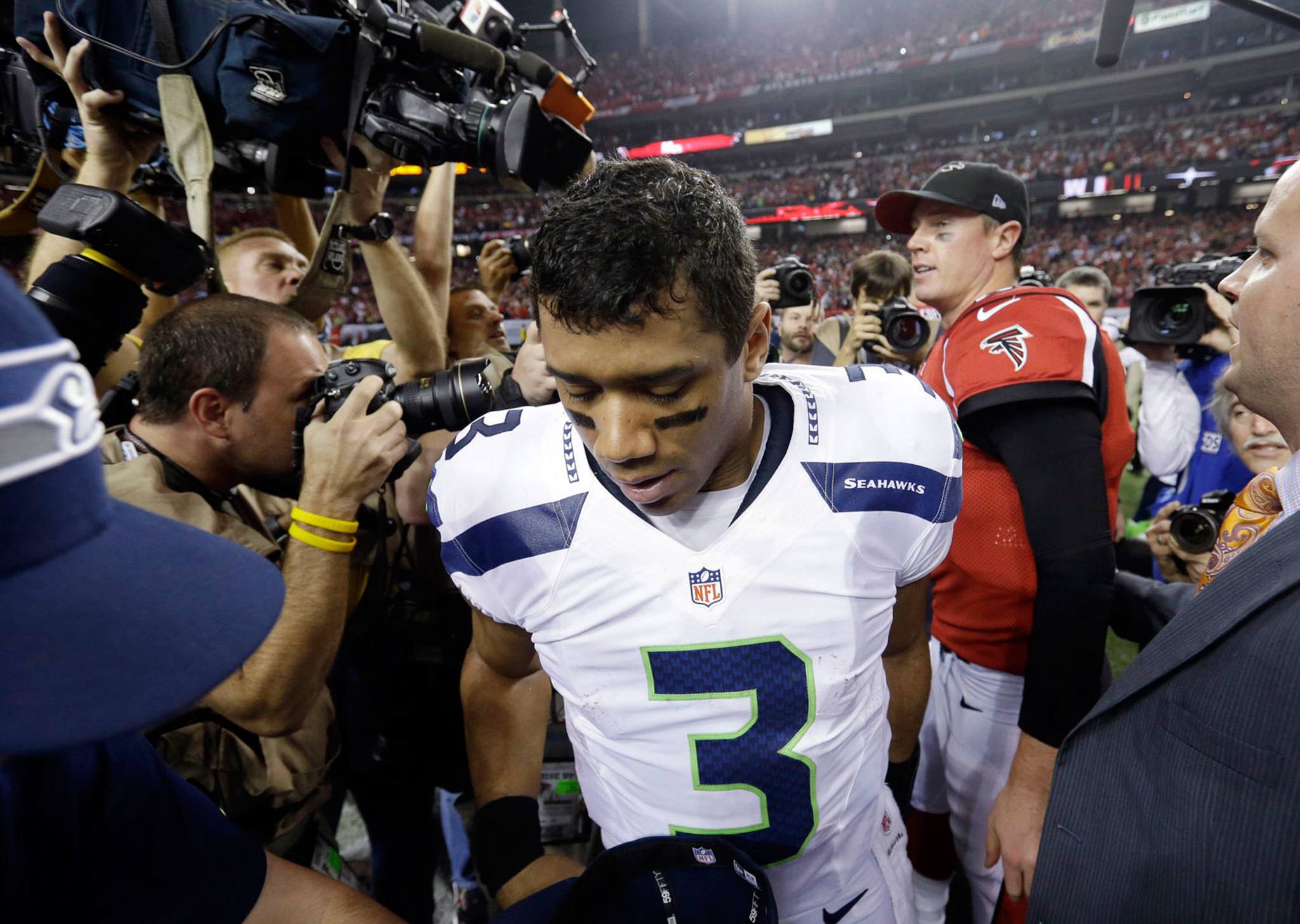 Seahawks quarterback Russell Wilson leaves the field after shaking hands with Falcons quarterback Matt Ryan after an NFC divisional playoff game Jan. 13, 2013, in Atlanta. The Falcons won 30-28. (AP Photo/David Goldman)