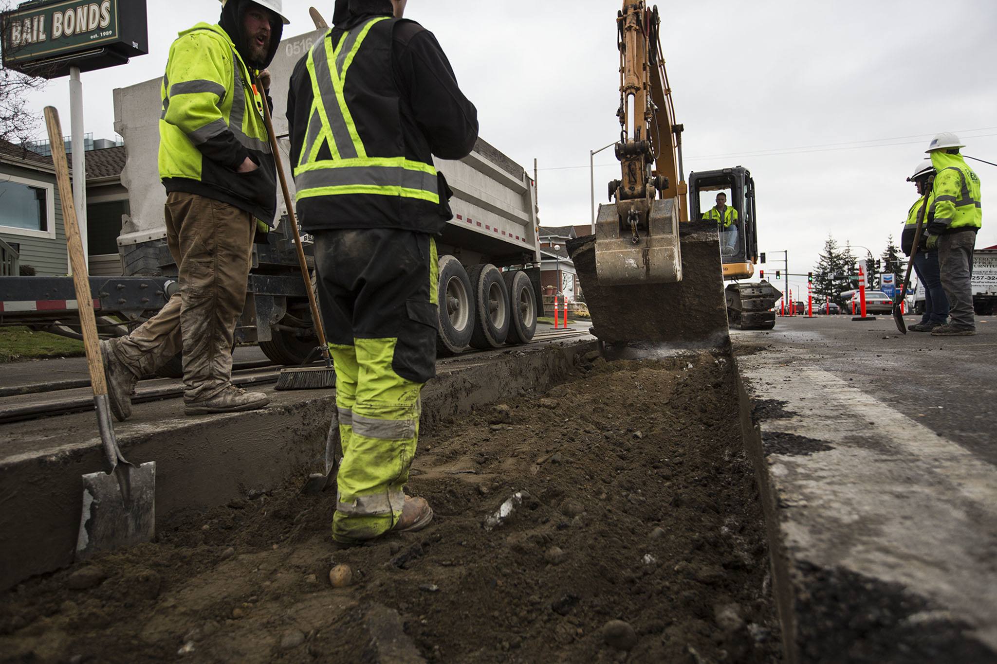 Construction crews remove chunks of concrete near the intersection of Broadway and Pacific streets on Monday in Everett. (Daniella Beccaria / The Herald)