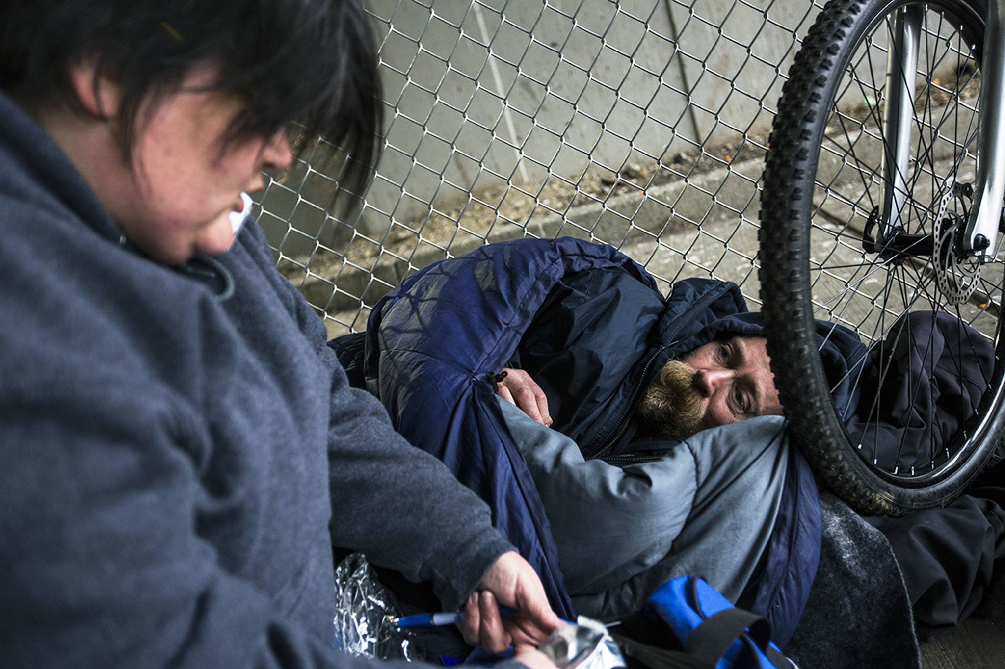 Gretchen Holtz, a volunteer from Compass Health, gathers information from Steve near the Everett Gospel Mission during the annual Point in Time Homeless Count on Tuesday in Everett. Volunteers conducted interviews throughout Snohomish County. (Daniella Beccaria / The Herald)