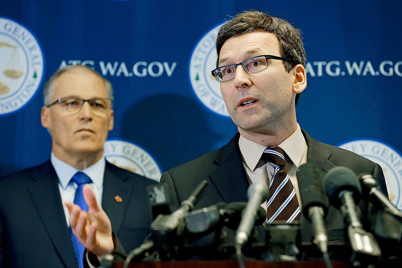 Washington Attorney General Bob Ferguson (right) talks to reporters with Gov. Jay Inslee on Monday in Seattle. Ferguson announced that the state is suing President Donald Trump over an executive order that suspended immigration from seven countries with majority-Muslim populations. (AP Photo/Ted S. Warren)