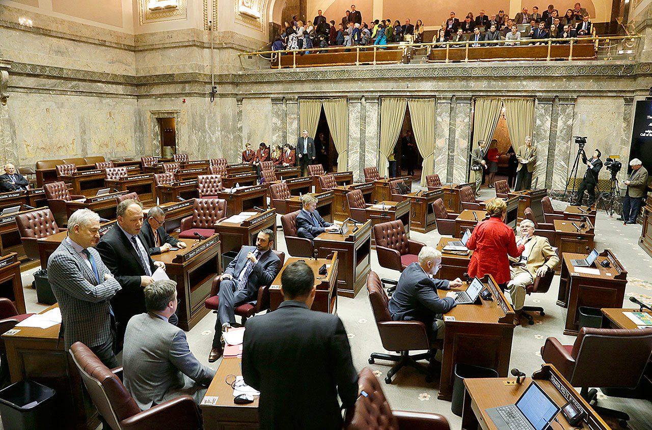 Democrats confer on the Senate floor as the Republican side sits empty during a recess Friday, Jan. 27, in Olympia. Senators were debating whether to vote on the “levy cliff” bill, which would delay a reduction in the amount of money school districts can collect though property taxes. (AP Photo/Ted S. Warren)