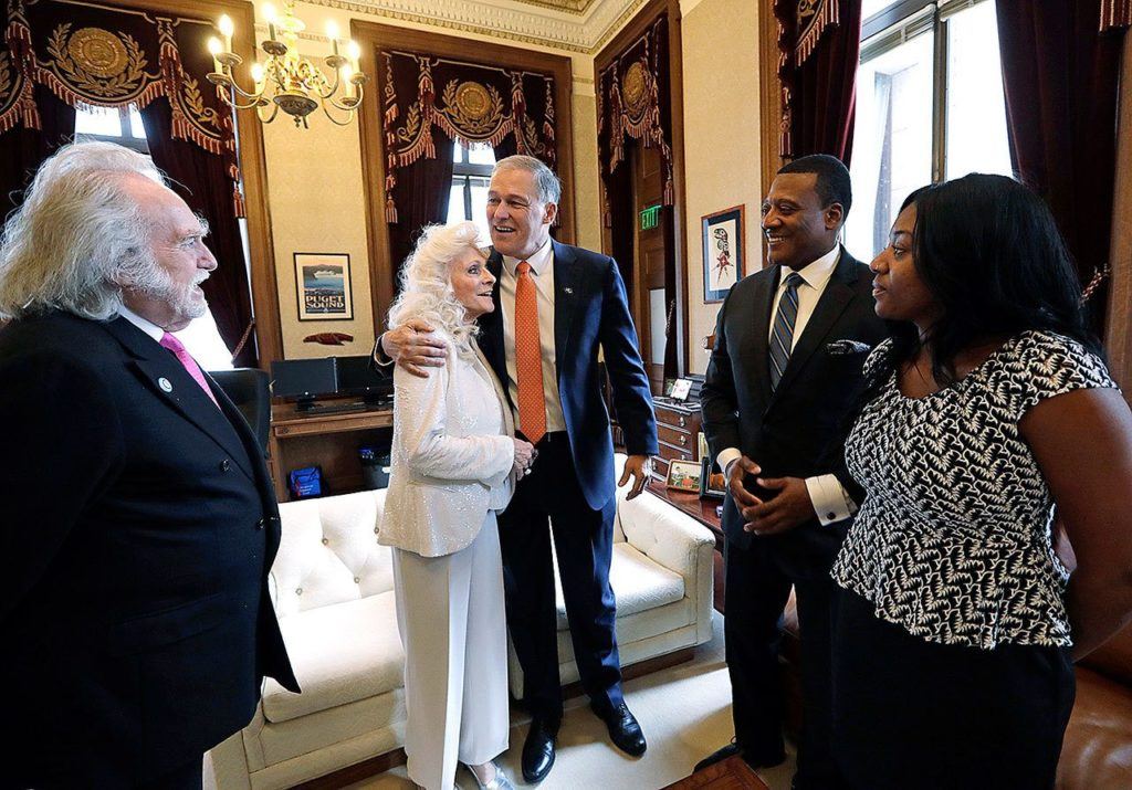 Washington Gov. Jay Inslee, center, embraces singer Judy Collins as they meet before his inaugural address to a joint session of the Legislature, Wednesday, Jan. 11, 2017, in Olympia, Wash. Looking on are Collins’ husband, Louis Nelson, left, Rev. Leslie Braxton and Braxton’s daughter, Karissa Braxton. Collins sang the national anthem and Braxton provided the invocation. (AP Photo/Elaine Thompson)
