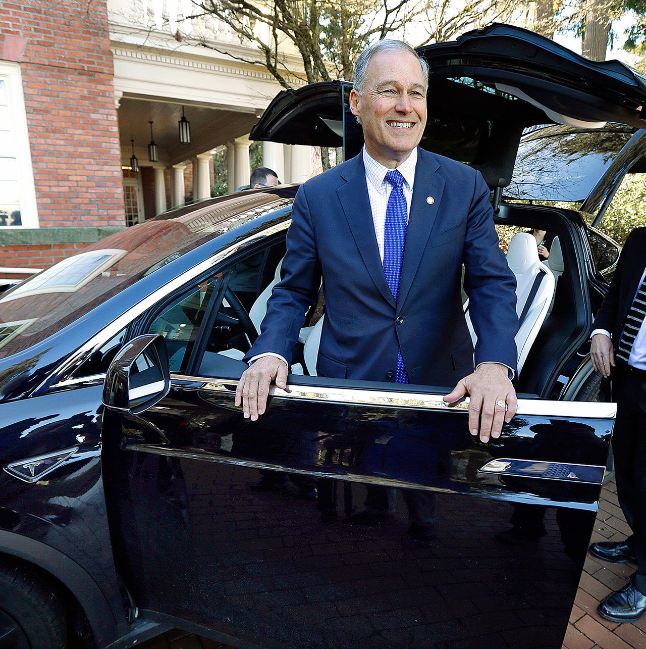 Washington Gov. Jay Inslee stands next to the driver’s-side door of a Tesla Model X 75D semi-autonomous electric vehicle before taking the car out for a test-drive Monday, Jan. 23, at the Capitol in Olympia. Inslee was test-driving the car to highlight the state’s role in the testing and development of autonomous vehicle technology and to tout the environmental and safety benefits of the vehicles. (AP Photo/Ted S. Warren)