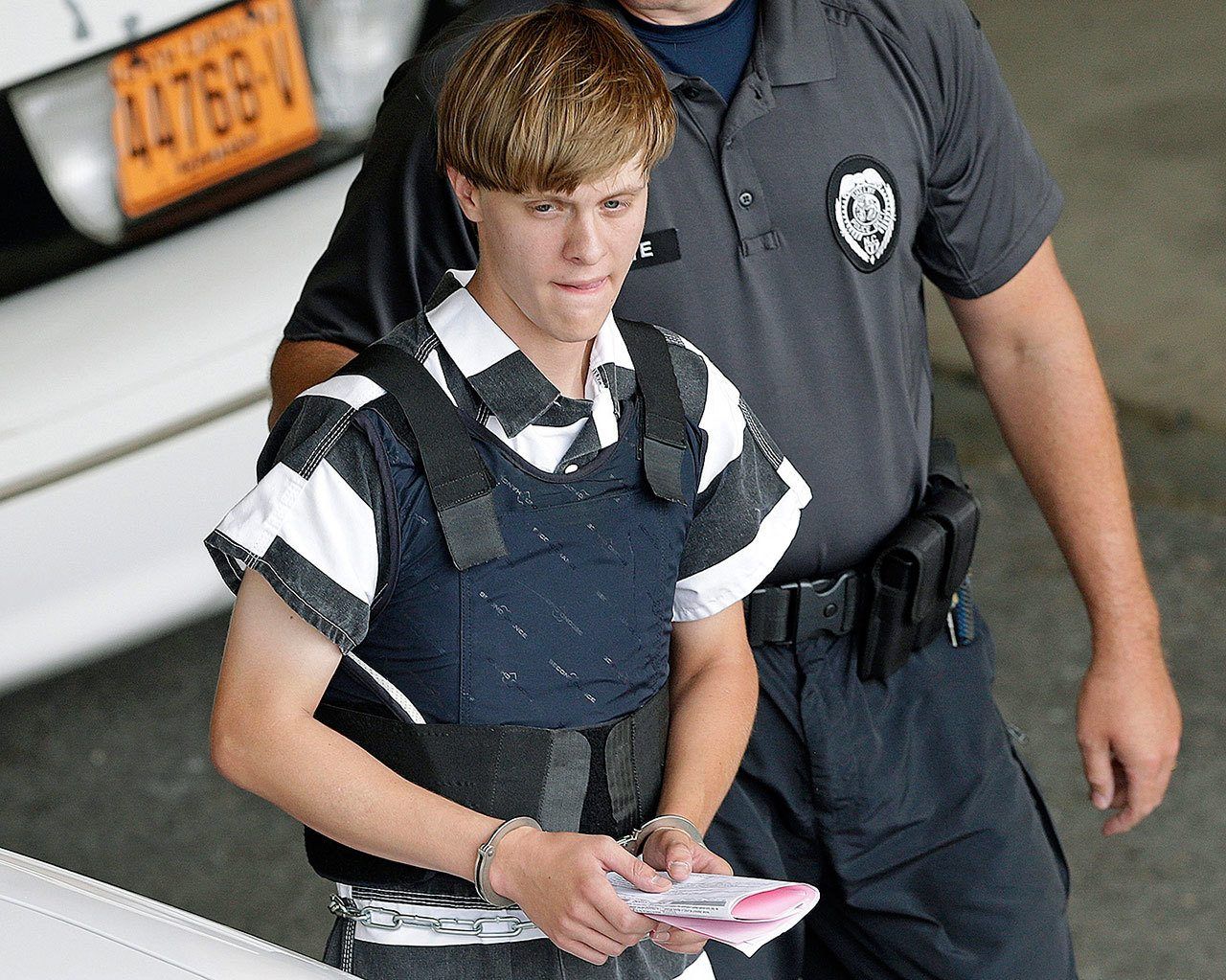 In this June 18, 2015 photo, Charleston, South Carolina shooting suspect Dylann Storm Roof is escorted from the Cleveland County Courthouse in Shelby, North Carolina. He could face the death penalty or life in prison. (AP Photo/Chuck Burton, File)