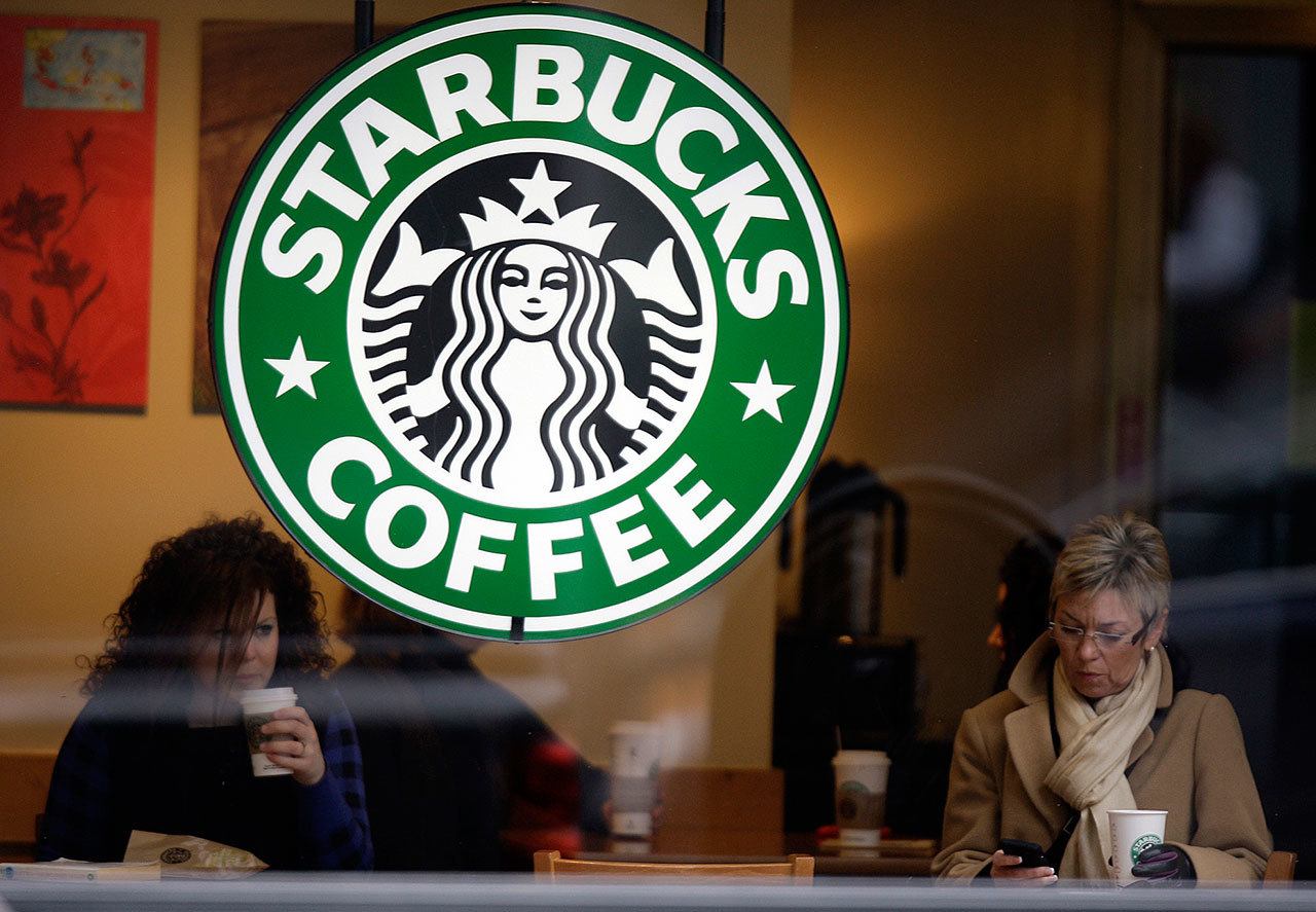 Customers drink coffee and check messages inside a Starbucks Coffee store in downtown Indianapolis. (AP Photo/Michael Conroy)