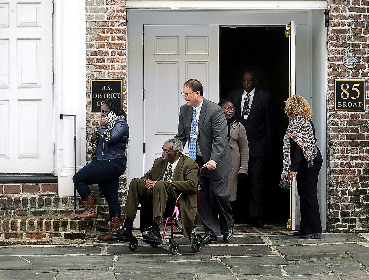 The Rev. Spike Coleman pushes John Pinckney, father of the Rev. Clementa Pinckney, one of the Emanuel Church shooting victims, as they leave the U.S. District Court on Tuesday, Jan. 10, in Charleston, South Carolina. (Grace Beahm/The Post And Courier via AP)