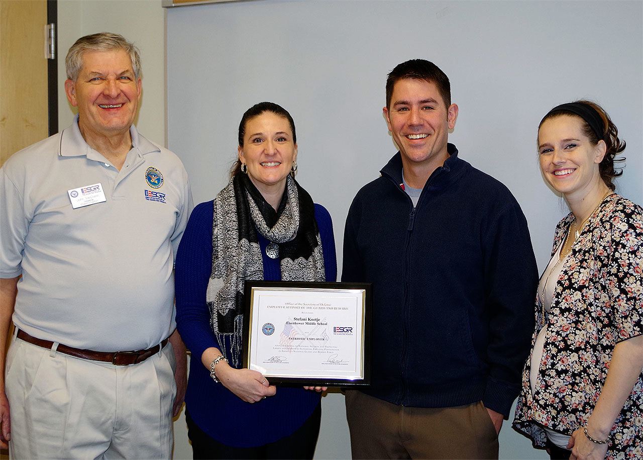 John Van Dalen (left) and Sgt. 1st Class Jamie Hawley (right) of the Washington Employer Support of the Guard and Reserve Committee present Eisenhower Middle School Principal Stefani Koetje with a Patriot Award Jan. 10. Koetje was nominated by counselor and Army National Guard Maj. Morgan Wolff (center right). (Contributed photo)