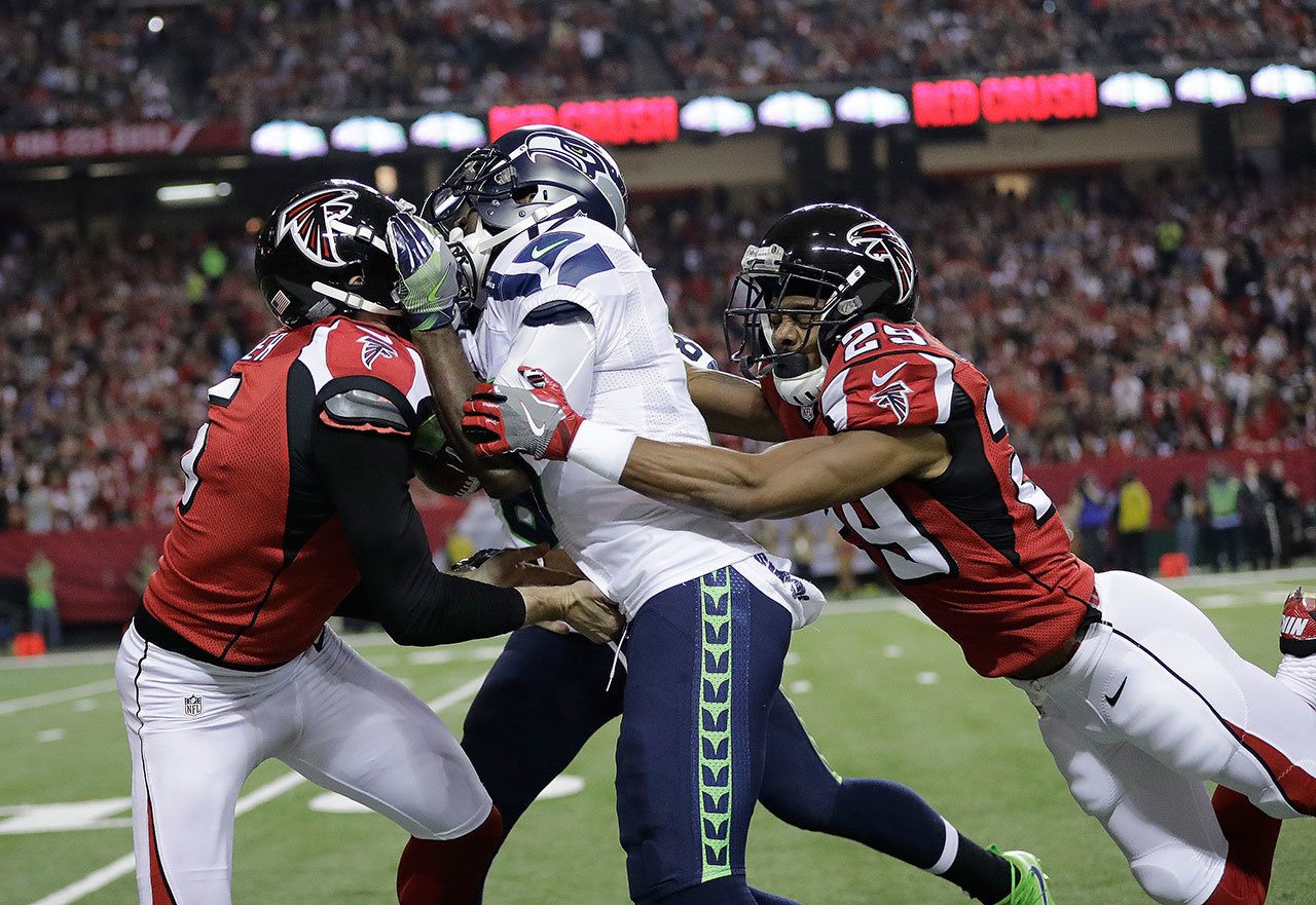 Falcons punter Matt Bosher (5) and cornerback C.J. Goodwin (29) tackle the Seahawks’ Devin Hester (17) during a punt return in the first half of a playoff game Saturday in Atlanta. (AP Photo/David Goldman)