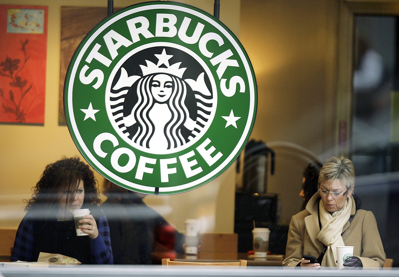 In this 2010 photo, customers drink coffee and check messages inside a Starbucks Coffee store in downtown Indianapolis. (AP Photo/Michael Conroy, File)
