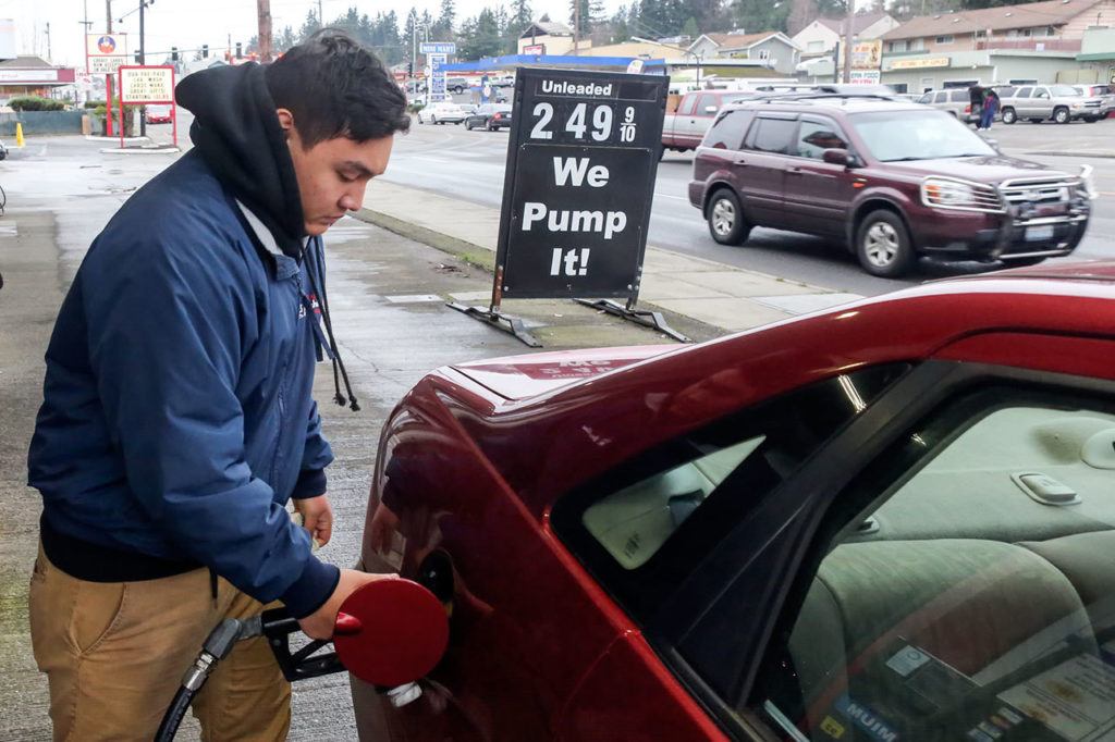 Andrew Caindoy pumps gas at General Brushless Car Wash, a full-service gas station and car wash in Everett. (Kevin Clark / The Herald)
