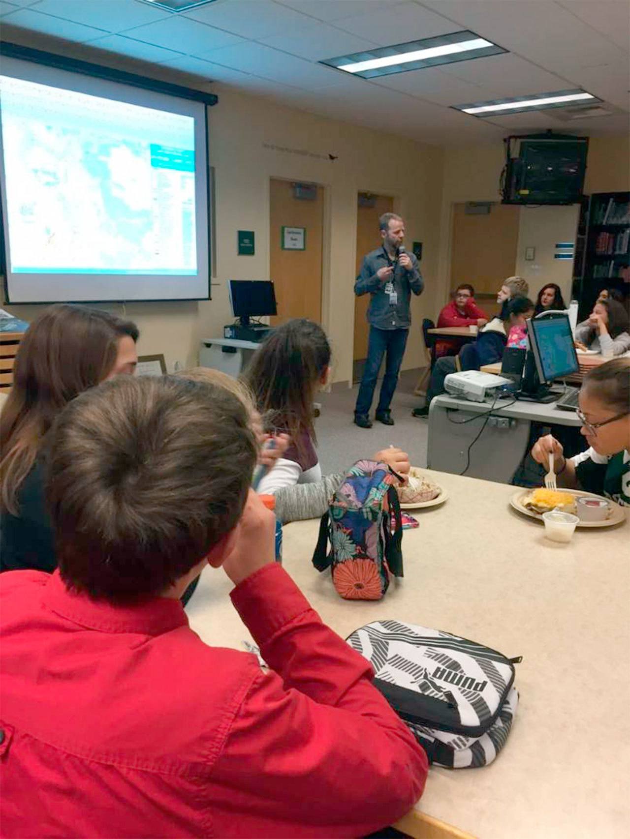 Evergreen Middle School students eat lunch as they learn about STEM-related careers from Snohomish County Principal Planner Randy Middaugh during a Lunch and Learn session. (Contributed photo)