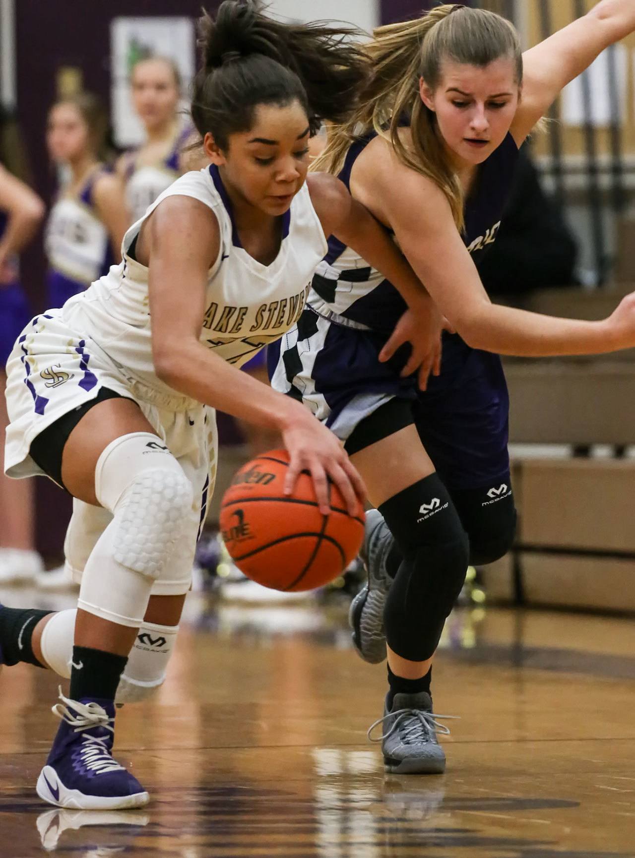 Lake Stevens’ Raigan Reed (left) and Kamiak’s Alex Gallaher vie for control of a loose ball Wednesday night in Lake Stevens. The Vikings won 65-61. (Kevin Clark / The Herald)