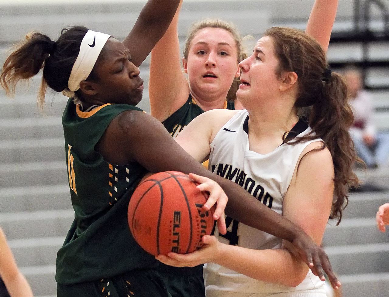 Lynnwood’s Kelsey Rogers (right) struggles for a shot attempt with Shorecrest’s Jazlyn Owens (left) and Audrey Dietz (rear) defending on Wednesday night at Lynnwood High School. Lynnwood won 48-32. (Kevin Clark / The Herald)