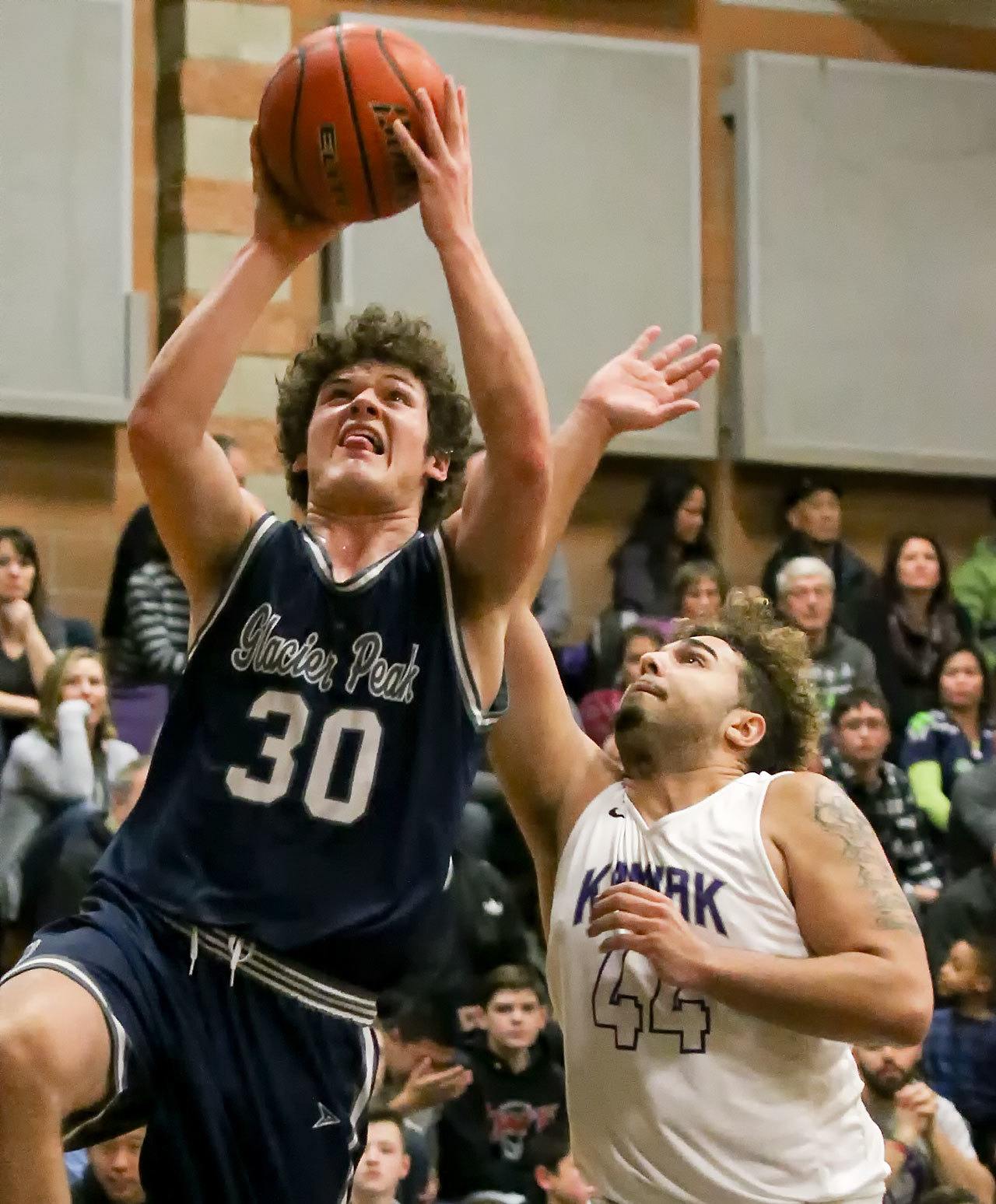 Glacier Peak’s Bobby Martin attempts a shot with Kamiak’s Swell Ewing defending Friday night at Kamiak High School in Mukilteo. The Grizzles won 63-50. (Kevin Clark / The Herald)