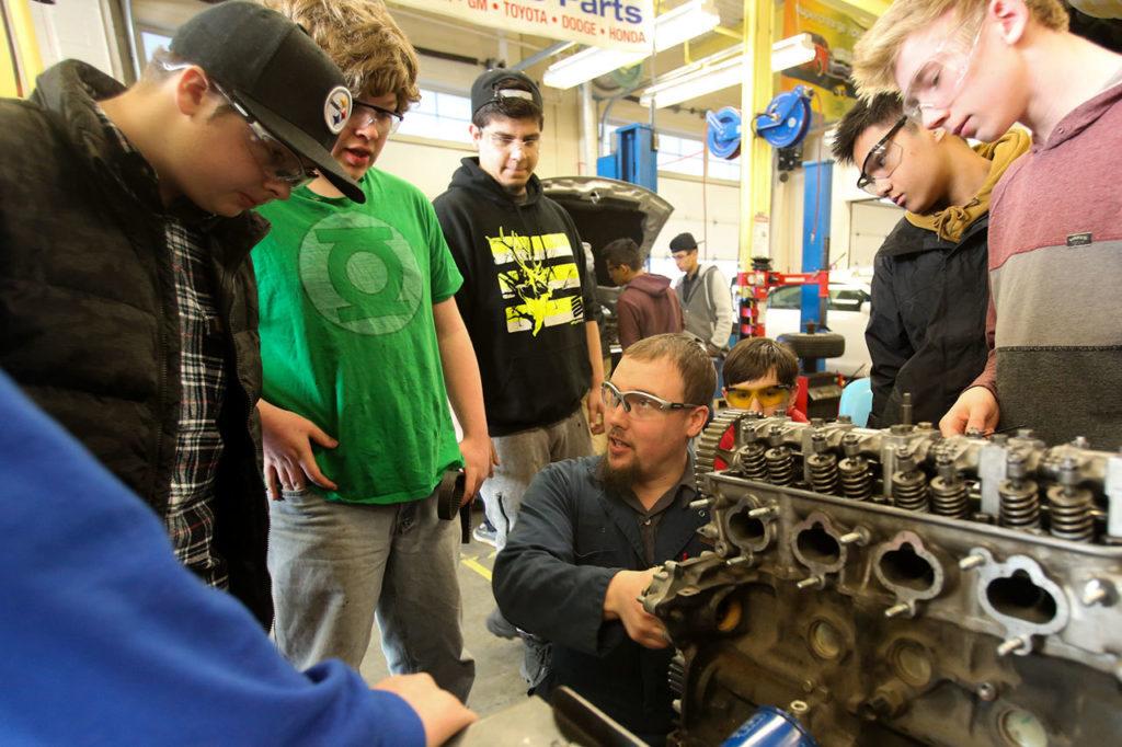 Bryan Robbins (center) explains a component of an engine Thursday afternoon at Meadowdale High School in Lynnwood. (Kevin Clark / The Herald)
