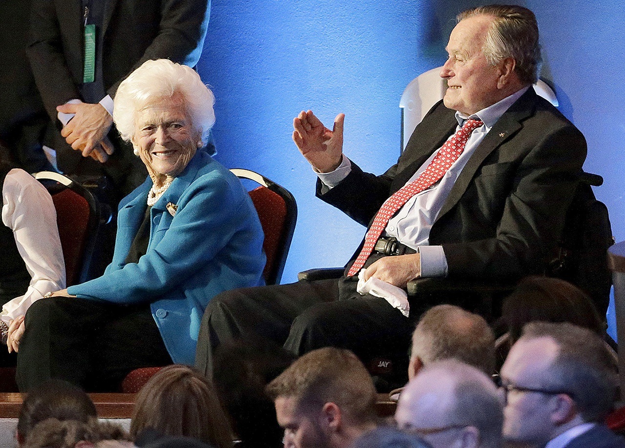 In this Feb. 25, 2016 photo, former President George H. W. Bush and his wife, Barbara, are greeted before a Republican presidential primary debate at The University of Houston in Houston. (AP Photo/David J. Phillip)