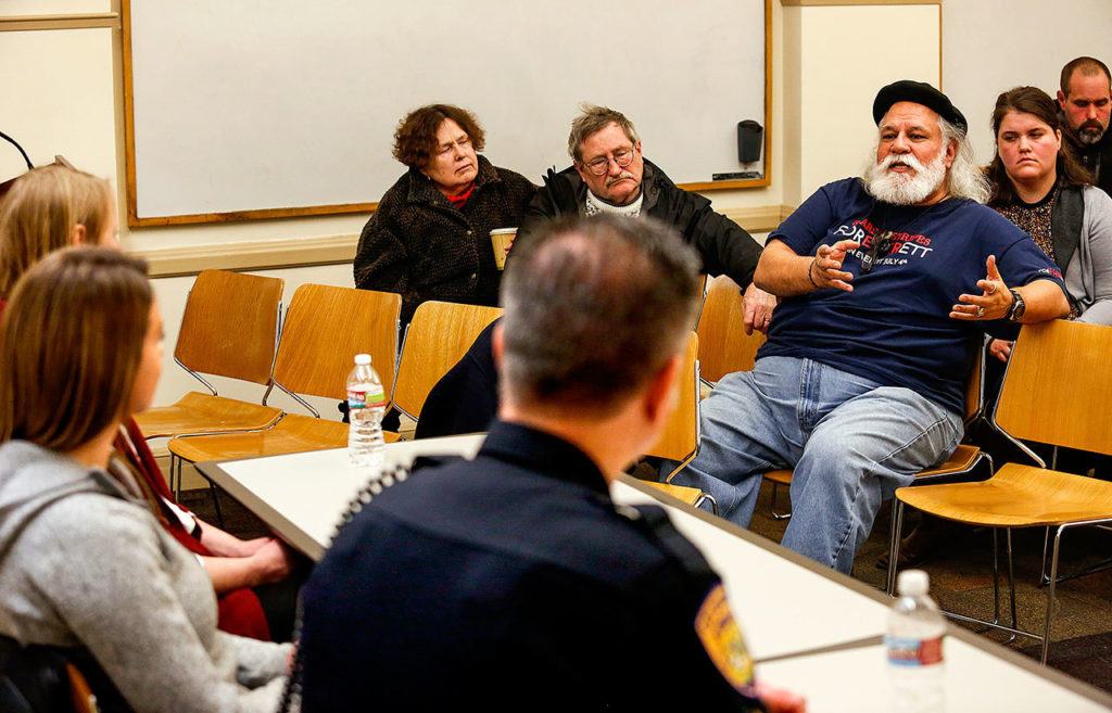 The social workers, Dowd and McCole, and Sgt. Mike Braley listen as Michael Trujillo (facing, center) speaks Tuesday night at the Everett Public Library. (Dan Bates / The Herald)
