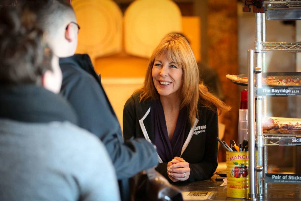 Vicki Evola, co-owner of Brooklyn Bros. Pizzeria, works the counter at the downtown Everett site. She likes to work the front counter, especially after events at Xfinity Arena, to get a feel for her customers. (Kevin Clark / The Herald)
