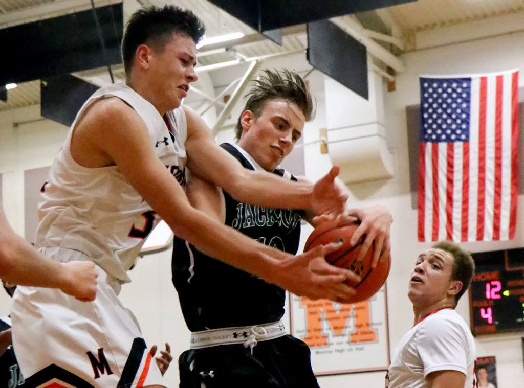 Monroe’s Spencer Davidson (left) and Jackson’s Ian Willgress battle for control of a rebound during a game Friday night at Monroe High School. Monroe won 70-58. (Kevin Clark / The Herald)
