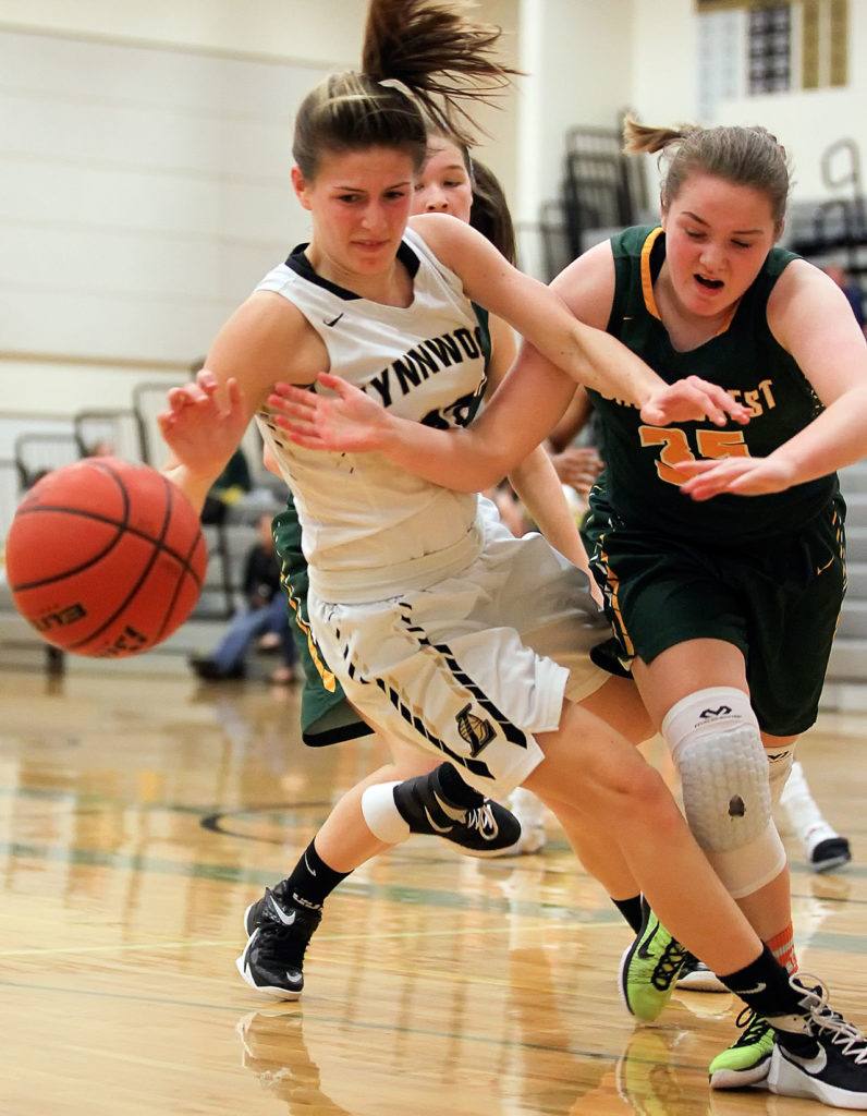 Lynnwood’s Taylor Fahey (left) and Shorecrest’s Sydney VanNess vie for control of a loose ball Wednesday night at Lynnwood High School. Lynnwood won 48-32. (Kevin Clark / The Herald)
