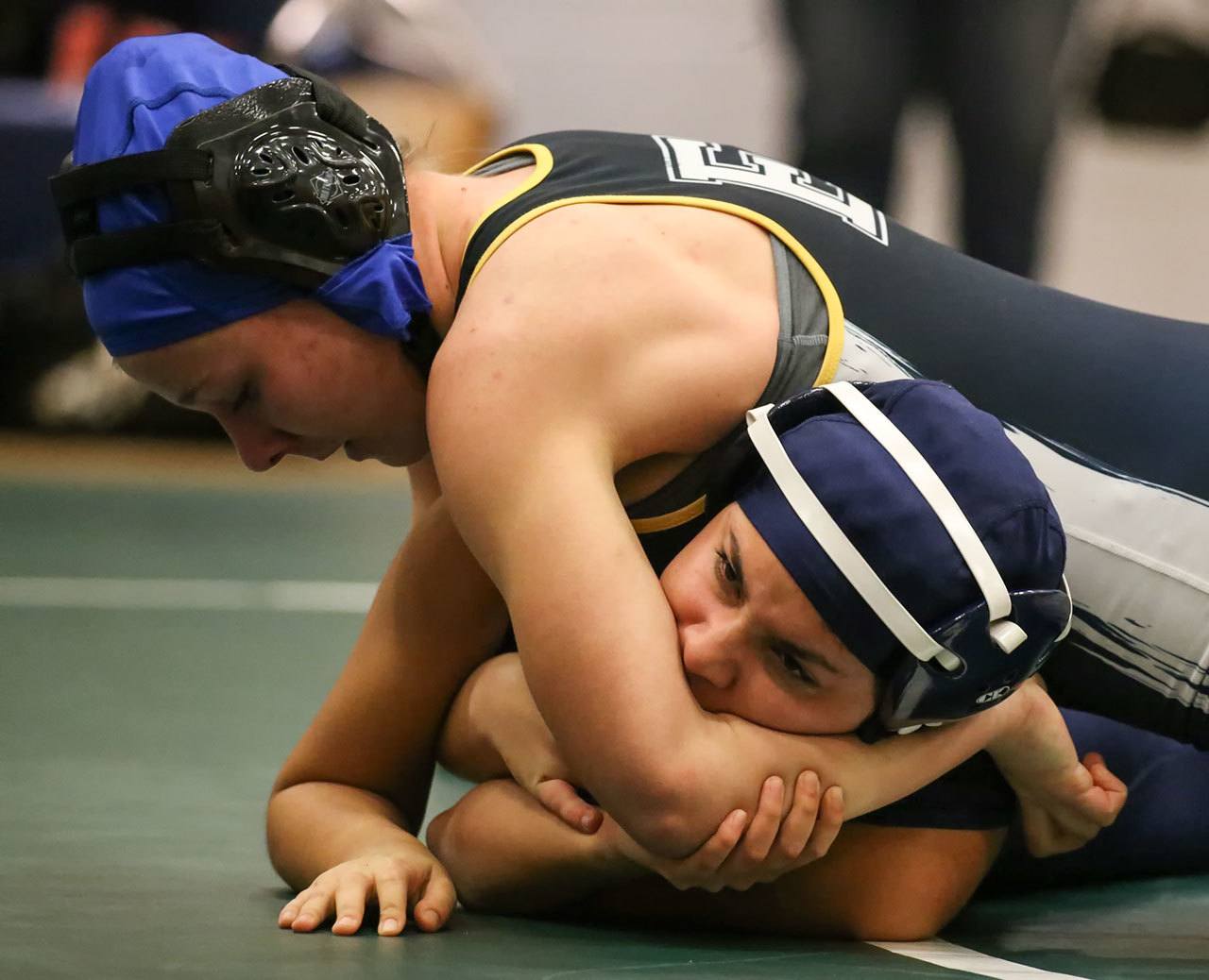 Everett’s Sierra Chapman (top) wrestles Arlington’s Itzel Ceja during a match Thursday night at Everett High School. (Kevin Clark / The Herald)