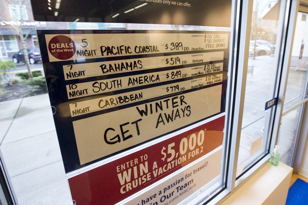 A board listing current cruise ship vacation deals is seen at an Expedia CruiseShipCenters franchise in Mill Creekճ Town Center. (Ian Terry / The Herald)
