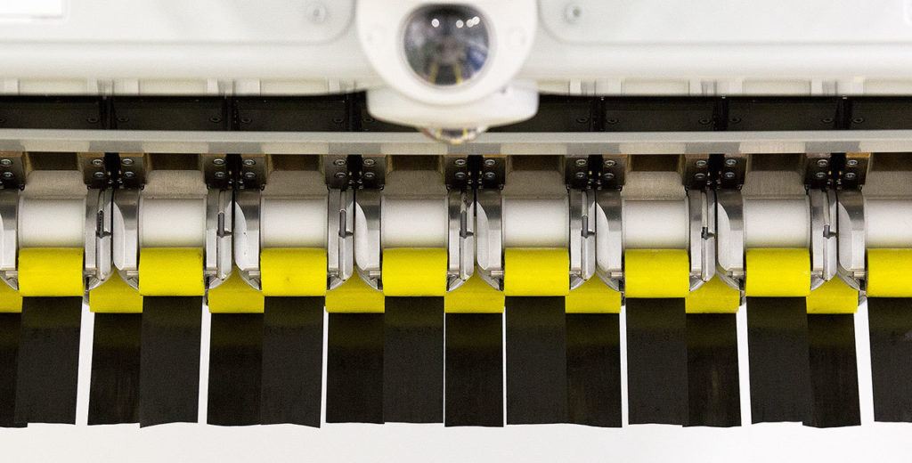At Boeing’s Composite Wing Center, carbon-fiber tape hangs from an Automated Fiber Placement machine before a test. The new 777X will be made with composite materials throughout the plane. (Andy Bronson / The Herald)

