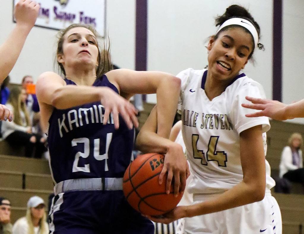 Kamiak’s Jamie Beirne (left) and Lake Stevens’ Kylee Griffen struggle for control of a rebound Wednesday night in Lake Stevens. The Vikings won 65-61. (Kevin Clark / The Herald)
