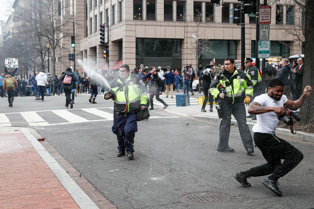Police officers fire pepper spray at protesters during a demonstration after the inauguration of President Donald Trump on Friday, Jan. 20, in Washington. (AP Photo/John Minchillo)