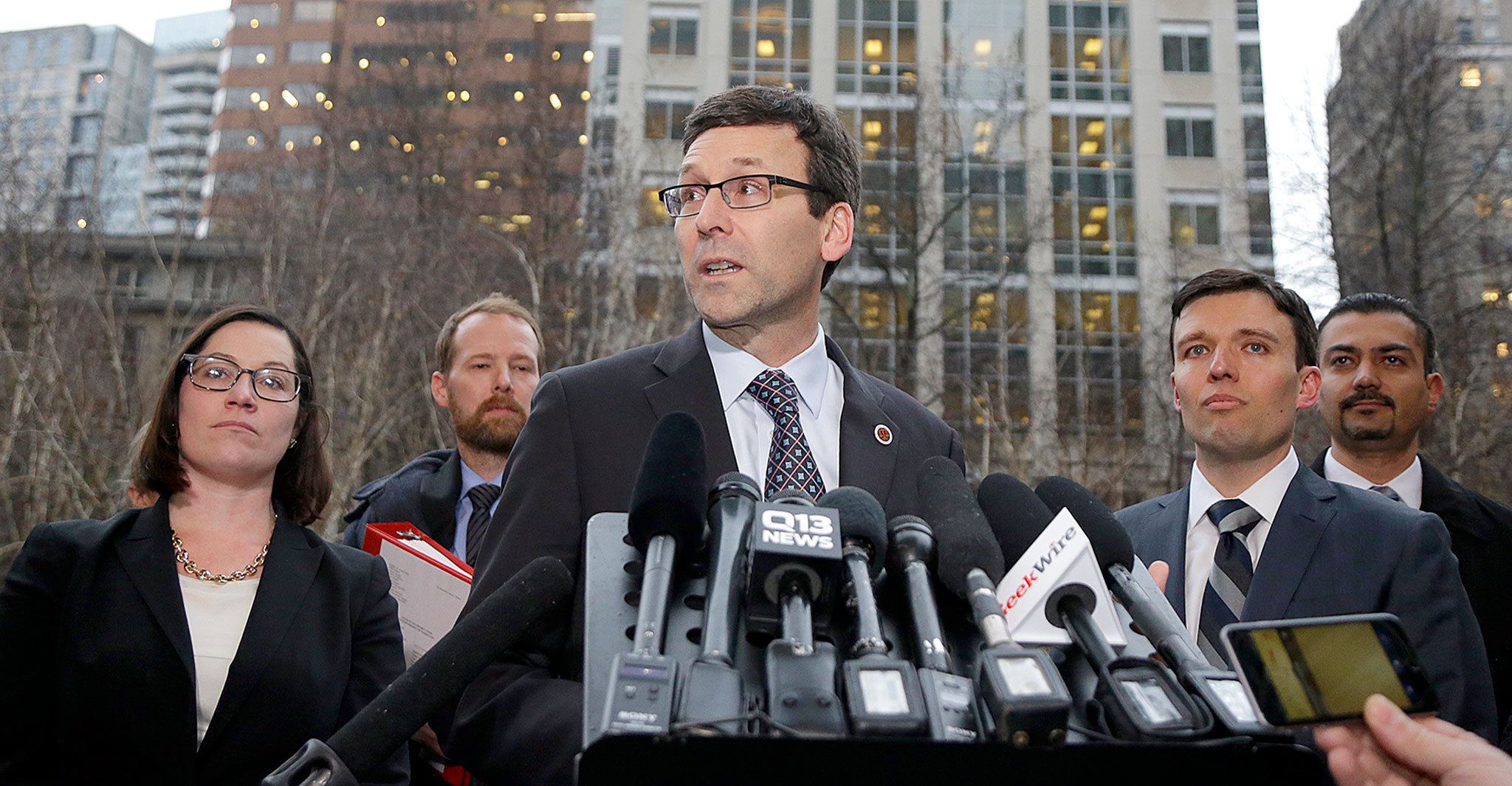 Washington Attorney General Bob Ferguson (center) talks to reporters as Solicitor General Noah Purcell (second from right) listens on Friday following a hearing in federal court in Seattle. (AP Photo/Ted S. Warren)