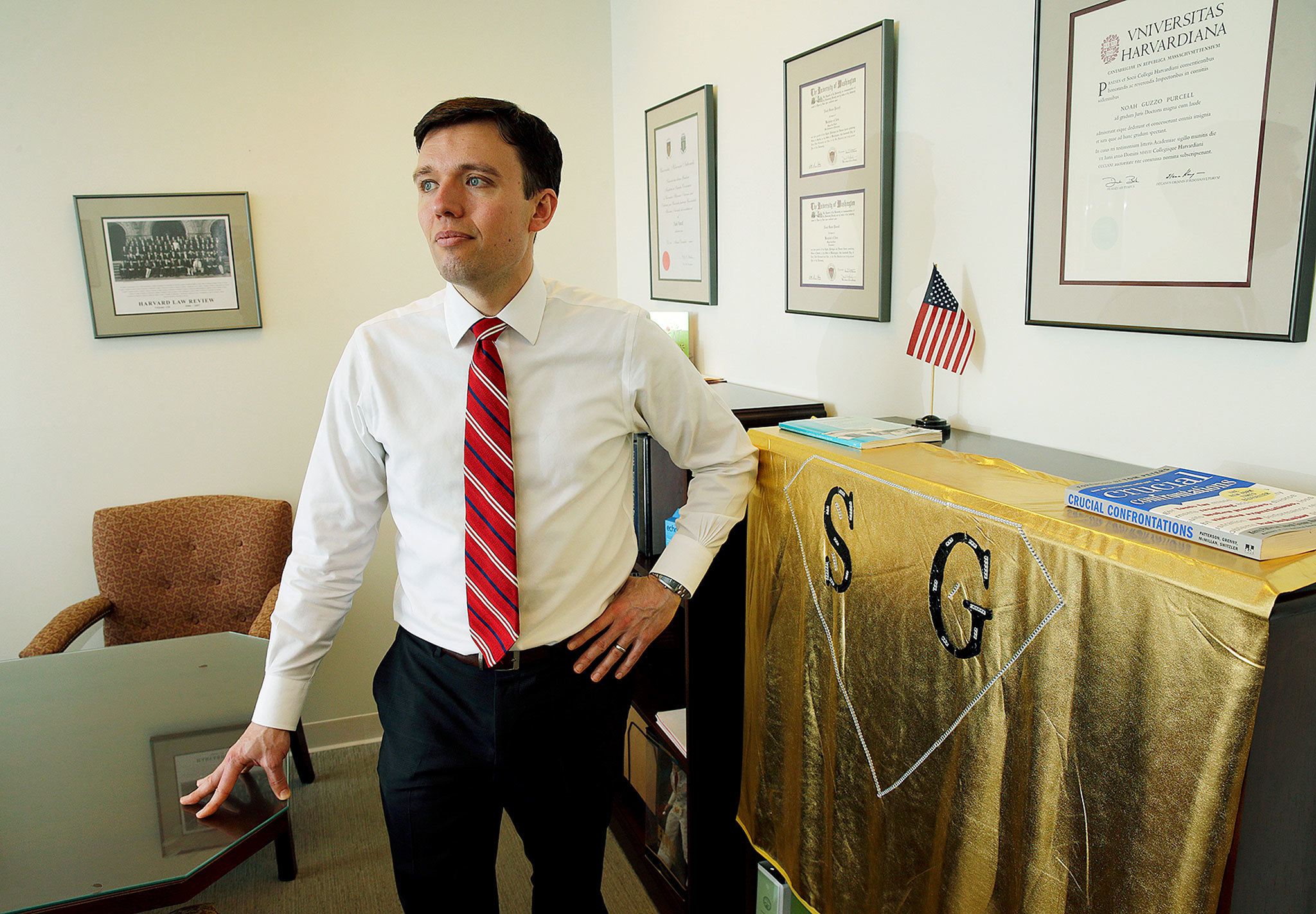Washington state Solicitor General Noah Purcell at his office in Seattle, where his honors law degree from Harvard and a gold “SG” superhero cape, made for him by a staff member, are on display. (AP Photo/Ted S. Warren)