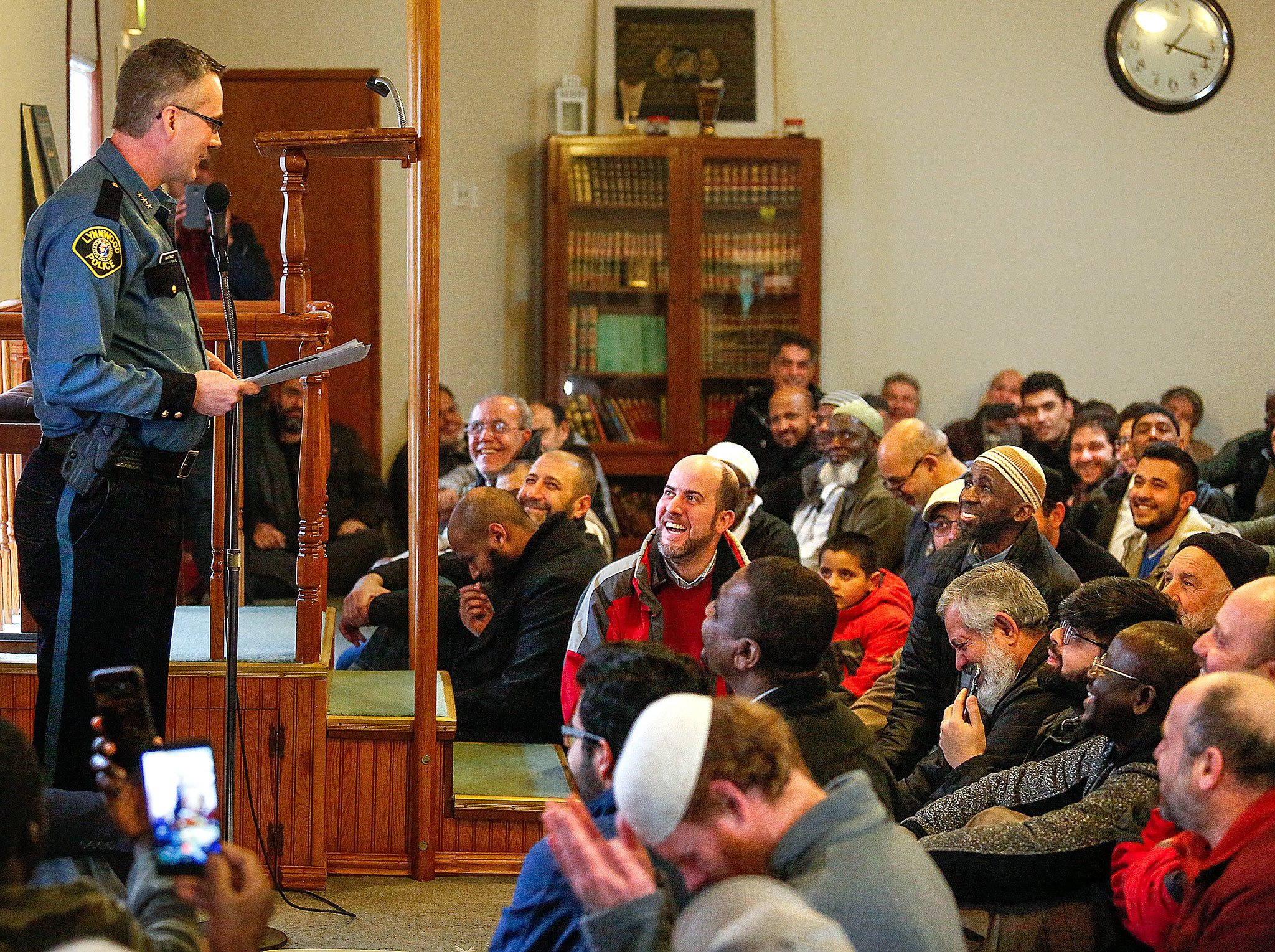 A packed crowd appears to receive Lynnwood Police Chief Tom Davis warmly Friday at the Evergreen Islamic Institute. Davis spoke about immigration policy and how the police department and Muslim community can work together. (Dan Bates / The Herald)