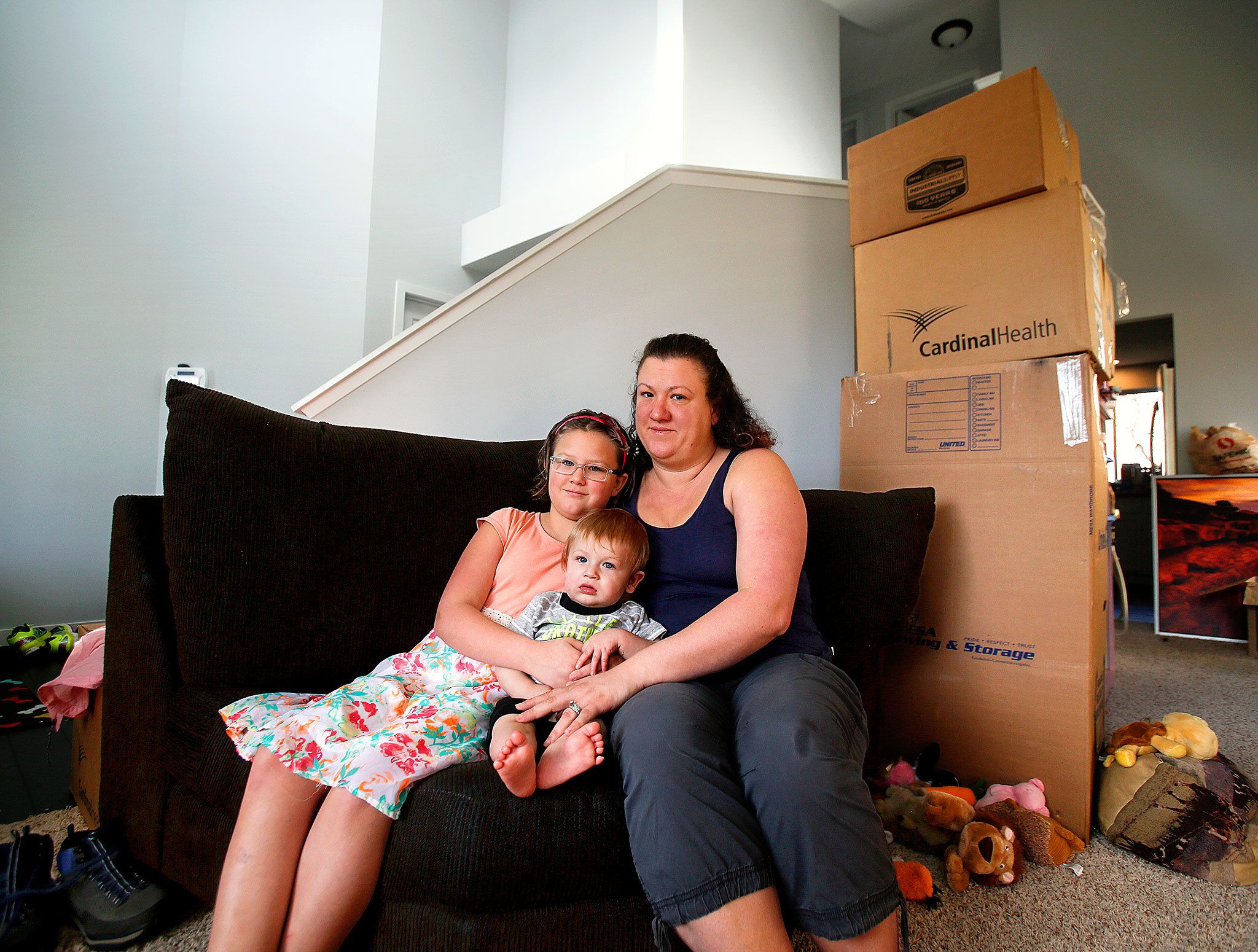 Maria Corcoran and her daughter, Ana, 8, hold her 11-month old son, Jimmy, at their new home in Lake Stevens Friday. Maria’s husband, Jay Corcoran, died on Valentine’s Day, just a week after the family moved from Utah to Lake Stevens. (Dan Bates / The Herald)