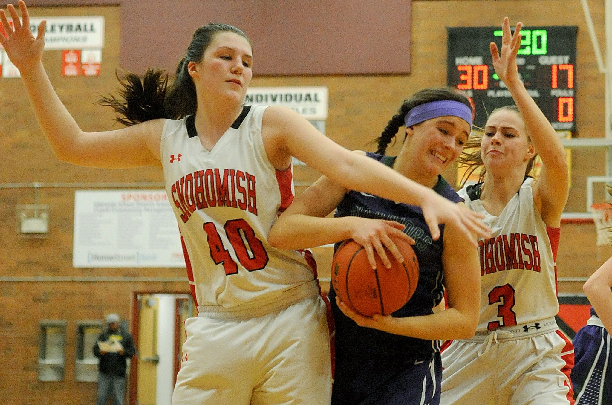 Edmonds-Woodway’s Kendra Cooper (center) wrestles for a rebound with Snohomish’s Courtney Perry (left) and Katie Brandvold during second-half action Tuesday in a 3A District semifinal game at Mountlake Terrace High School. (Doug Ramsay / For The Herald)