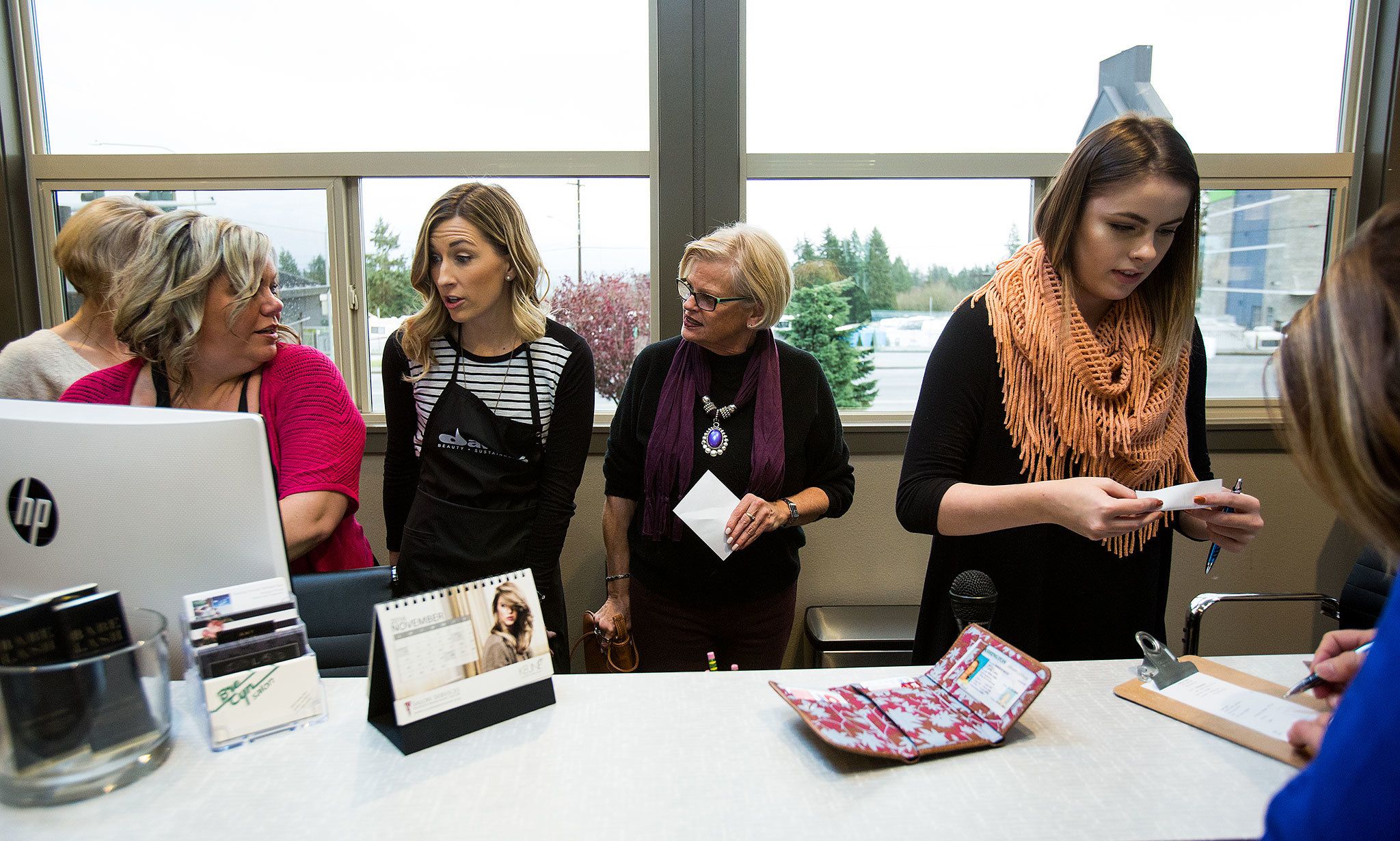 Cyndi Mitchell turned over her salon to 29-year-old Emily Douglas (the two in the center) after realizing she no longer had the energy to run BreCyn Salon. She gave the business to Douglas in stages and now works for Douglas twice a week. (Andy Bronson / The Herald)