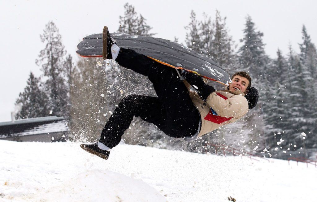 Jalen Velasquez, a junior at Stanwood High School, gets airborne after hitting a jump while sledding at the school on Monday. (Andy Bronson / The Herald)
