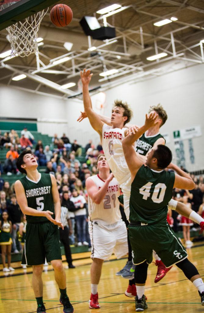 Stanwood’s AJ Martinka shoots the ball through Shorecrest defenders during the championship game of the 3A District 1 boys basketball tournament Feb. 17, 2017, at Jackson High School in Mill Creek. Shorecrest beat Stanwood 55-52. (Daniella Beccaria / The Herald)
