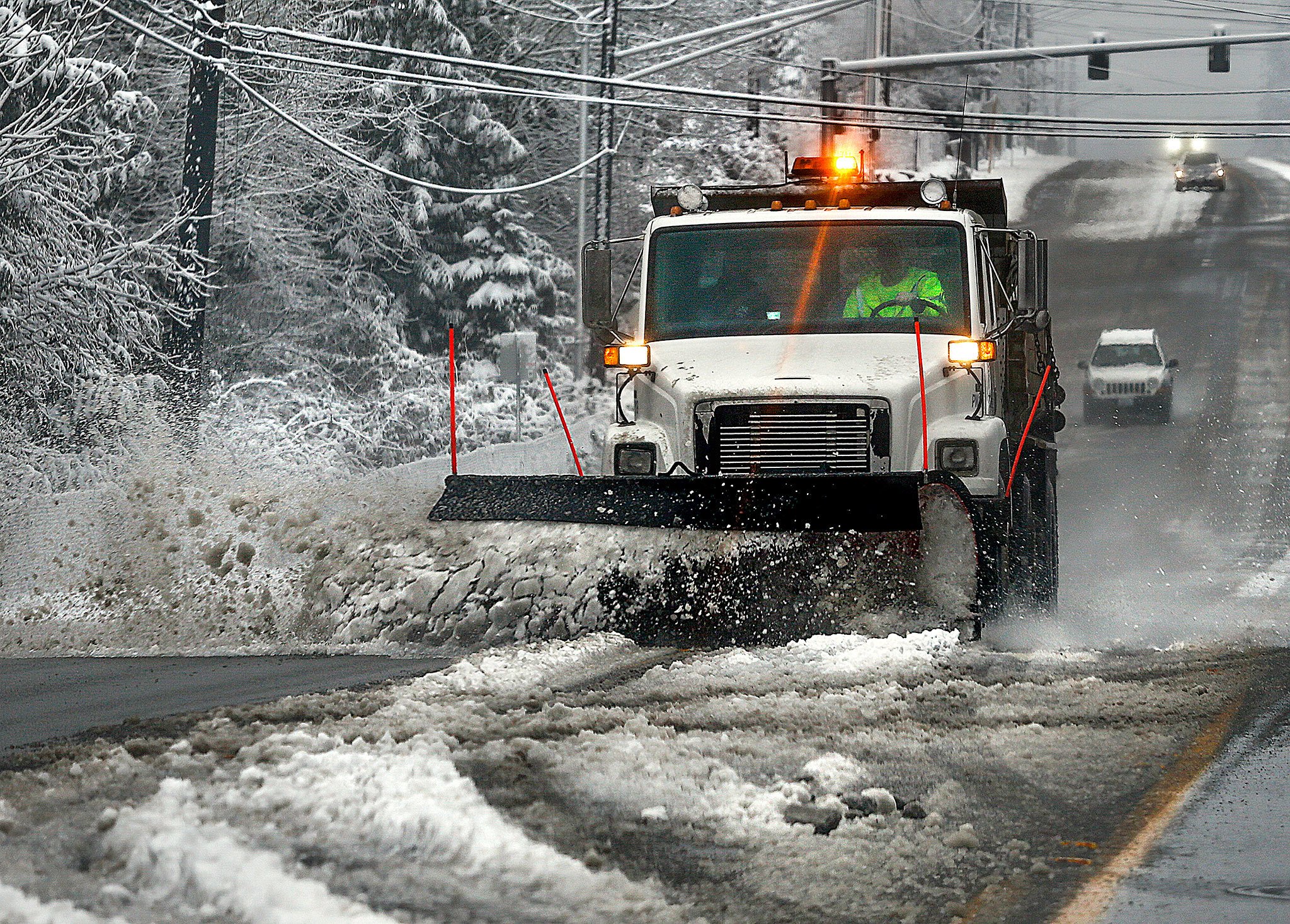 Snow plows, including this one on 20th Street SE between Everett and Lake Stevens, were clearing snow and slush from as many streets as possible before temperatures dropped again Monday night. (Dan Bates / The Herald)
