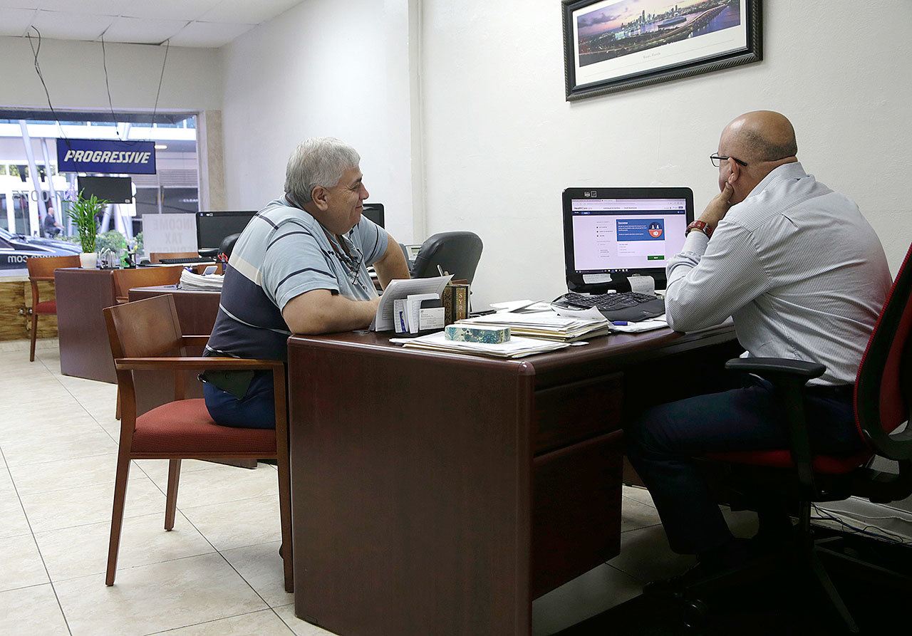 Sami Jamaleddine (left) signs up for health insurance offered under the Affordable Care Act with his insurance agent on Jan. 31 in Miami. (AP Photo/Lynne Sladky)