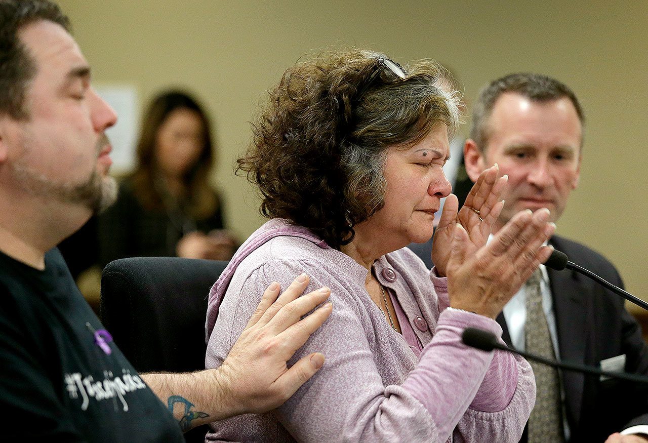 Marilyn Covarrubias (center) is comforted while testifying about the 2015 shooting death of her son by police. She spoke at a House Public Safety Committee public hearing in Olympia about bills intended to reduce the number of violent interactions between police and the public. (AP Photo/Elaine Thompson)