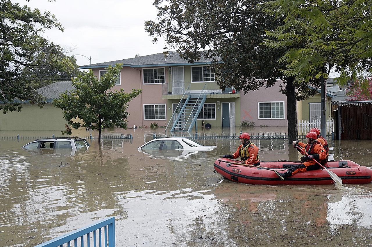 Rescuers travel by boat through a flooded neighborhood looking for stranded residents Tuesday, Feb. 21, in San Jose, California. (AP Photo/Marcio Jose Sanchez)