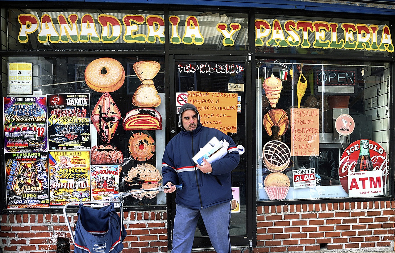 A mail carrier passes a closed bakery Thursday in south Philadelphia’s Italian Market. (AP Photo/Jacqueline Larma)